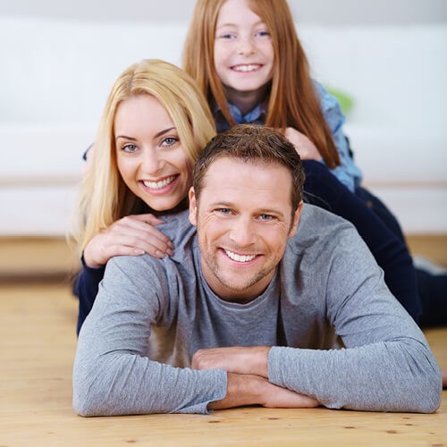 Happy family lying on flooring | Country Carpet & Furniture